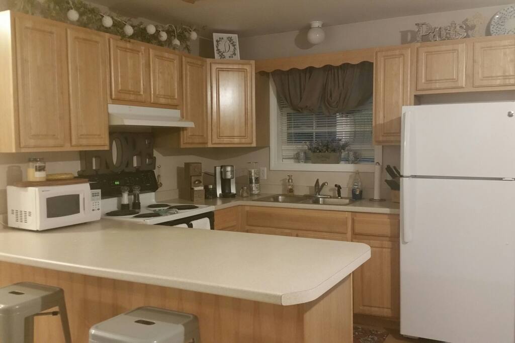 Full kitchen with stove top, oven, dishwasher, two bay sink, spacious fridge, microwave, and a bar with two stools. There is a coffee corner with all the amenities!