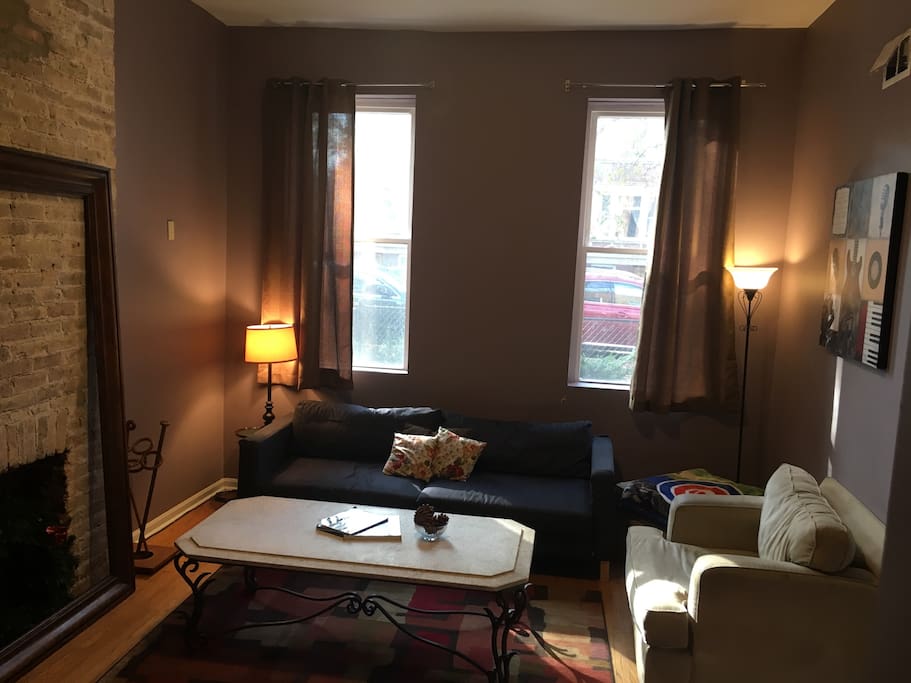 Front/Family room. Pictured are the floor to ceiling windows, a fold out couch (folds out to a queen and sheets, blankets and pillows are provided) along with an antique marble coffee table
