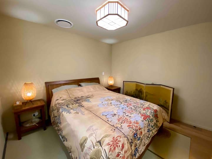 Chambre moderne de style japonais avec éléments japonais, qui sont Tokonoma (alcôve), Byobu (panneaux pliants en papier), tapis de tatami faits de précipitation, Shoji (fenêtres coulissantes en papier).