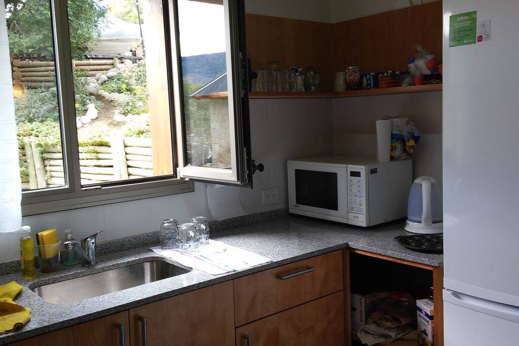 cocina completa heladera freezer y vista al jardín