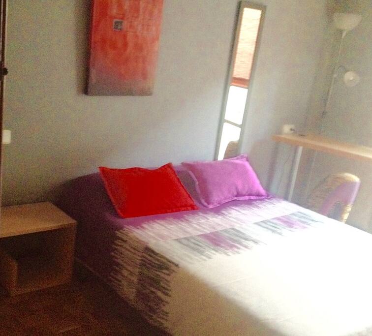 Habitación amplia y luminosa. Cama de 135cm con mesilla a un lado y espejo al otro.
