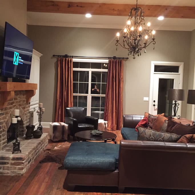 Living room with fireplace and 70 inch TV.