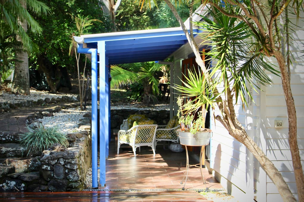 French doors open to the patio surrounded by tropical garden