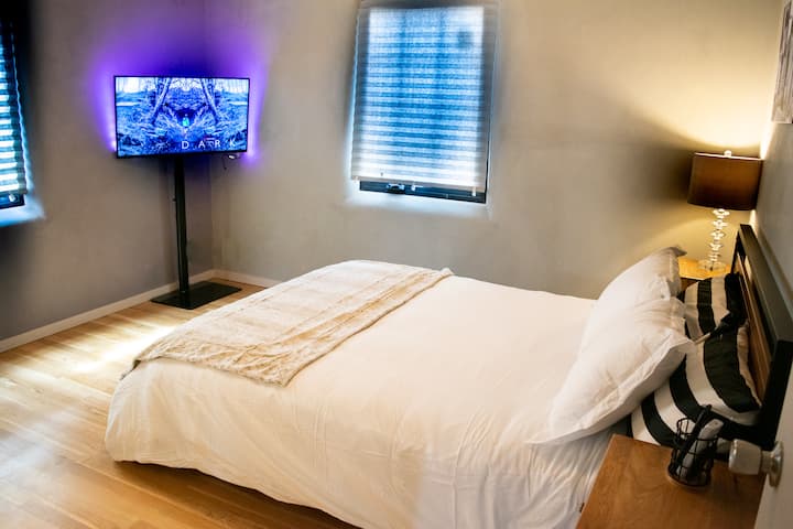 Dormitorio principal con una cama tamaño queen y un armario grande.