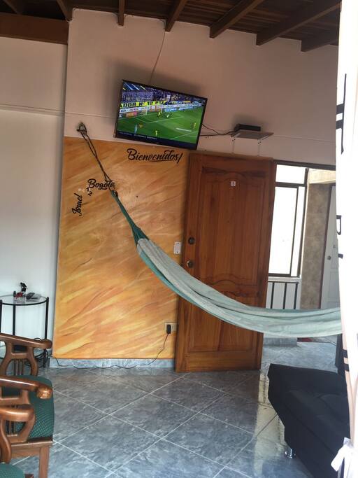Zona común con sofa, hamaca y tv