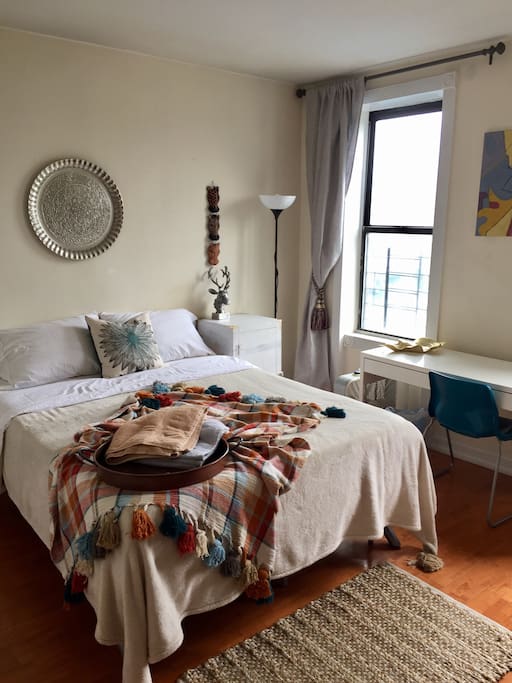 Queen bed, side table, stand lamp, linen curtains with tie-backs, desk and chair