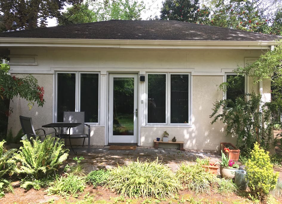 Patio with flowers in the spring looks out on a secluded backyard space with bird watching