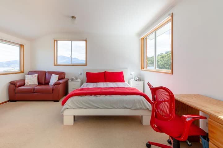 Dormitorio principal arriba. Cama QS, sofá, televisión, escritorio y armarios con espejos. 