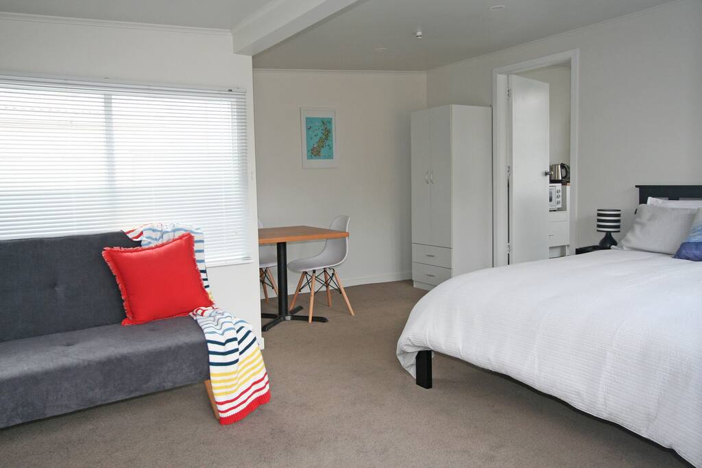 Bedsit/lounge area with queen bed, sofa couch, table and chairs, wardrobe, TV and WiFi throughout cottage.