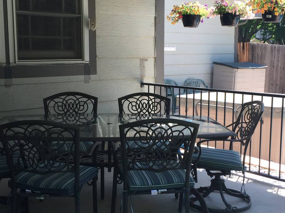 Outdoor dining area with hot tub behind