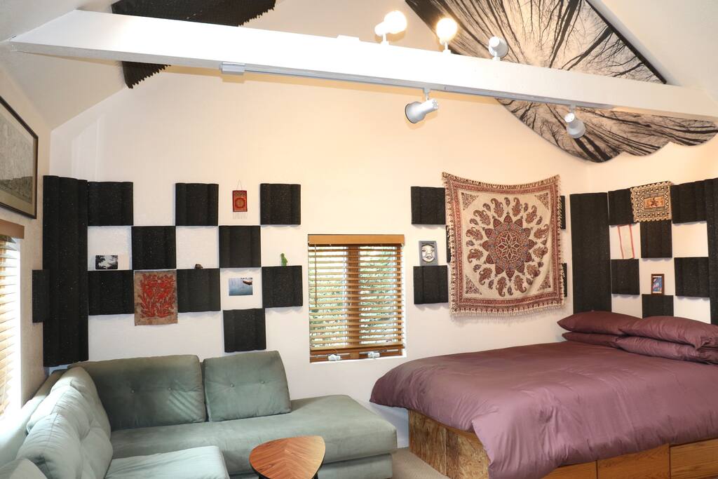 Main part of studio includes a queen size bed and full size L Shaped couch.