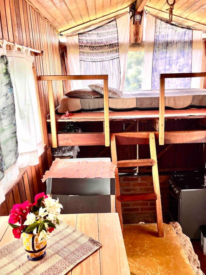 O charme do ambiente integrado do mezanino,
Cozinha  e mesinha de refeições. Repare na beleza da luz da manhã! Antes era uma cama em cima, agora o mezanino virou um pequeno lounge, onde vc pode curtir, ler, meditar, ver o nascer do sol e muito mais!