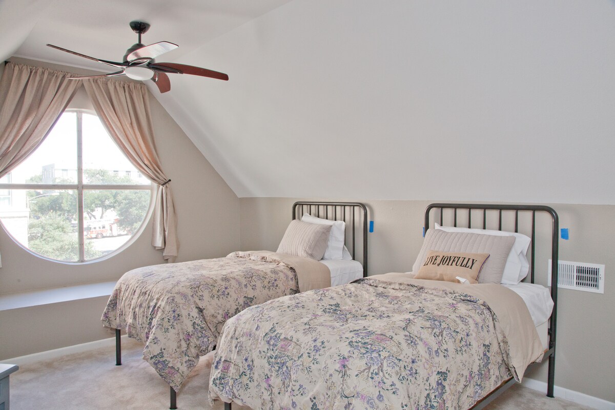 El cuarto y último dormitorio ofrece tres camas individuales con muebles elegantes, que proporcionan espacio adicional para grupos más grandes. Un santuario relajante con un toque moderno.