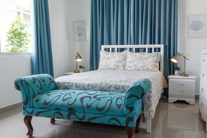 Cozy bedroom with a comfy bed, blue armchair, and natural light. Perfect for relaxing.  

Chambre confortable avec lit confortable, fauteuil bleu et lumière naturelle. Idéal pour se détendre.