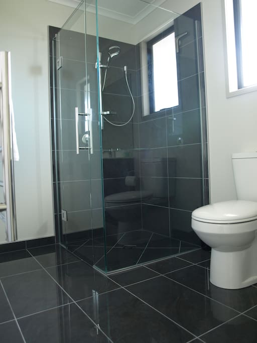The tiled floor glass shower with an amazing shower head that drenches you.