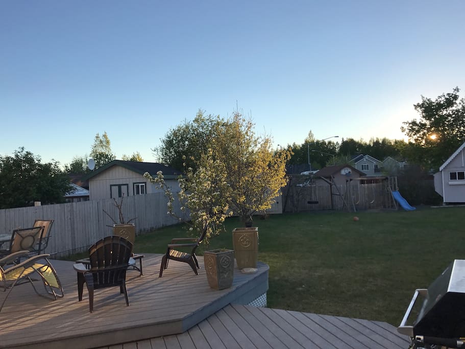 View out into the yard in late afternoon/evening. There are pear trees, apple trees)multiple kinds, and a cherry tree in the back yard. This area is perfect having bbqs, relaxing on deck chairs, enjoying a nightly fire, playing catch or just sitting outside to enjoy the fresh air.