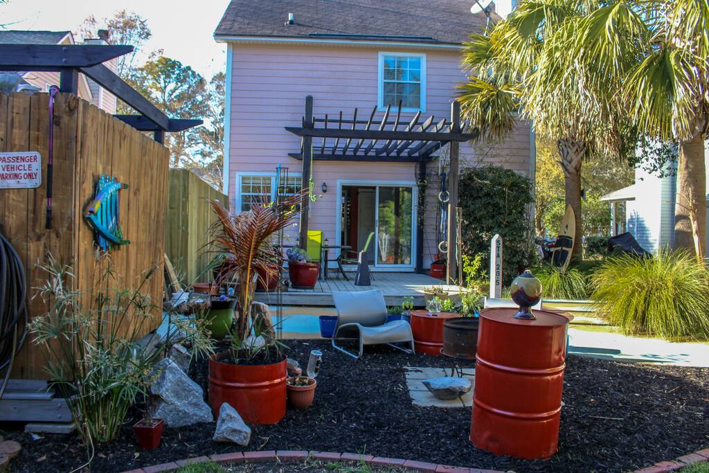 View of main house, fire pit and outdoor spa from back yard.