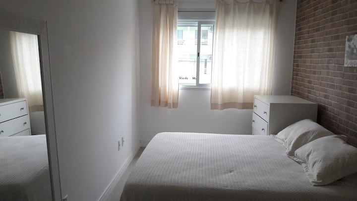 Sovrum med dubbelsäng och fönster.