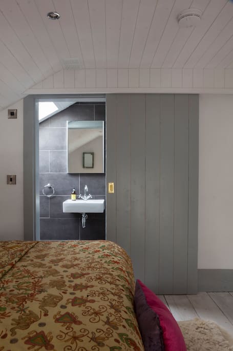 The ensuite bathroom of the Hayloft bedroom. Each room has a super-king sized bed with crisp white lined, quirky rustic interior and ensuite bathroom.