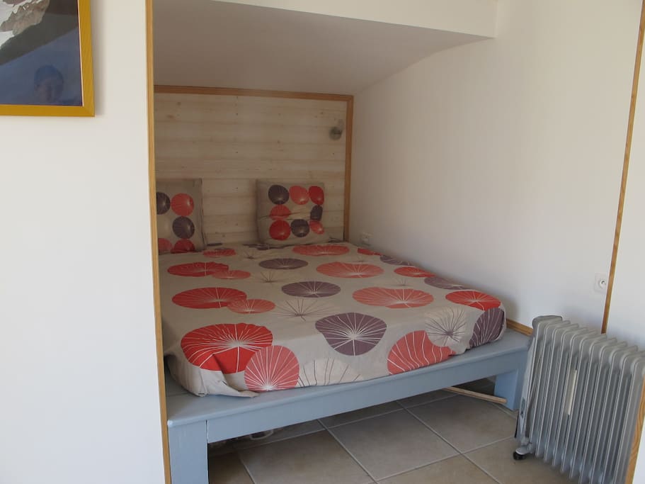 Le lit double en alcôve avec canapé, bureau et dressing