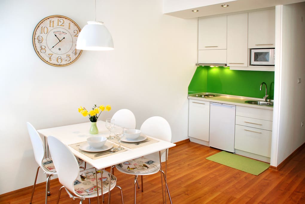 Dining table conveniently next to kitchen with food basics included