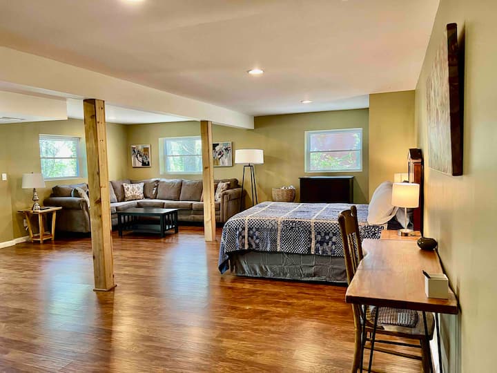 GRANDE CHAMBRE - LIT QUEEN SIZE au niveau inférieur et coin détente et coin détente avec canapé, télévision, SALLE DE BAIN . Accès dans un jardin par une porte vitrée coulissante.