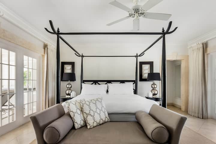 Een prachtig ontworpen hoofdslaapkamer met een Brits super kingsize bed, uitzicht op het zwembad, airconditioning, plafondventilator, kluis, kledingopslag en een prachtige eigen bad- en doucheruimte.