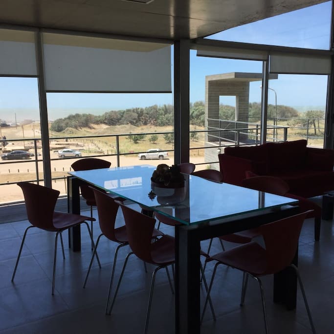 Living Comedor todo vidriado con vista al mar y al bosque