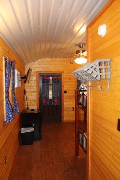 Front Room also equipped with a ceiling fan, coat hooks, shelving space, and a broom and dustpan