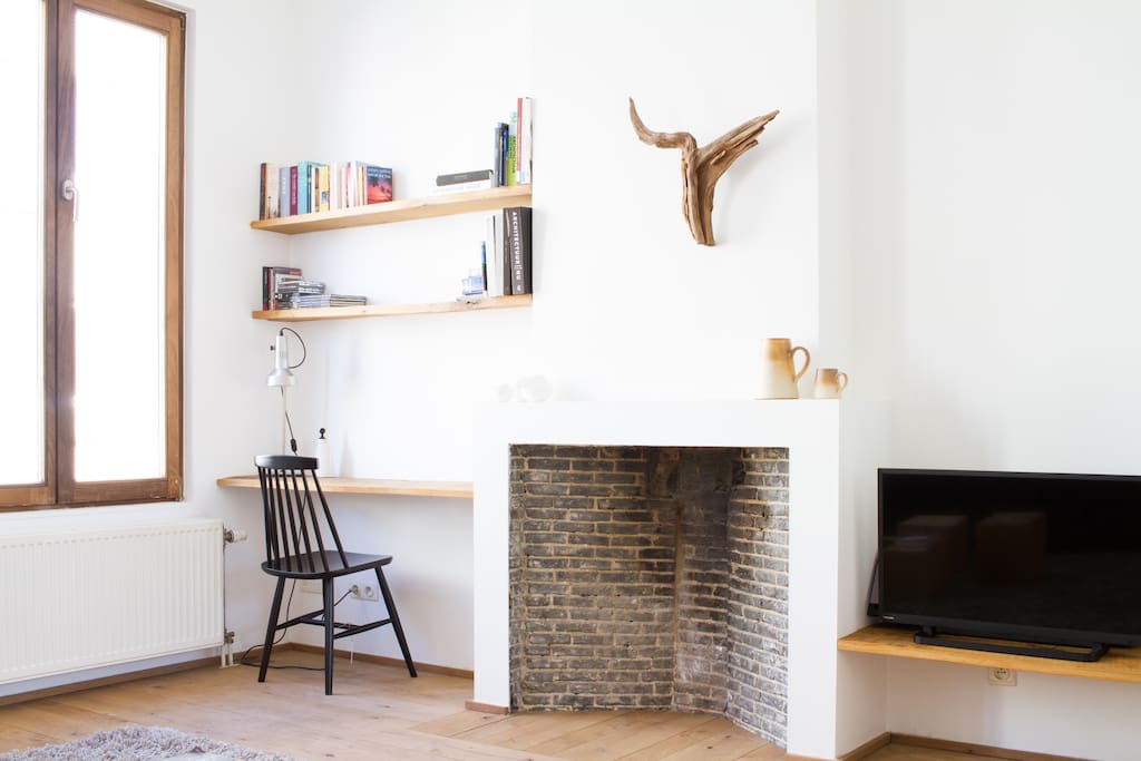 Old fireplace / desk with library / tv + stereo