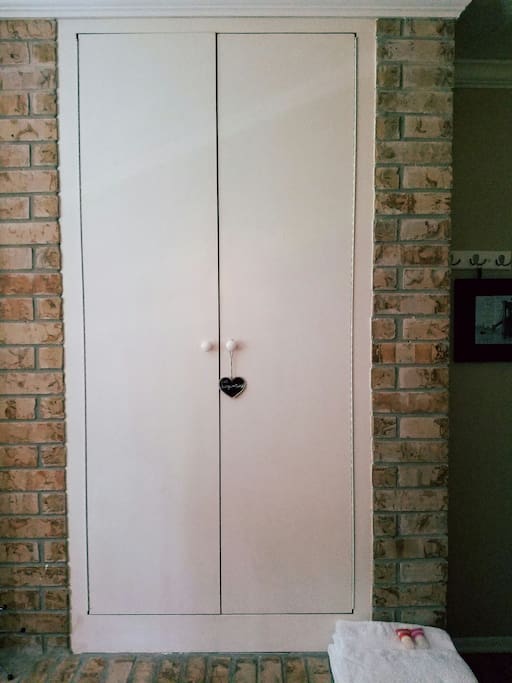 Closet space in converted fireplace. Luggage stand and hooks for your convenience.