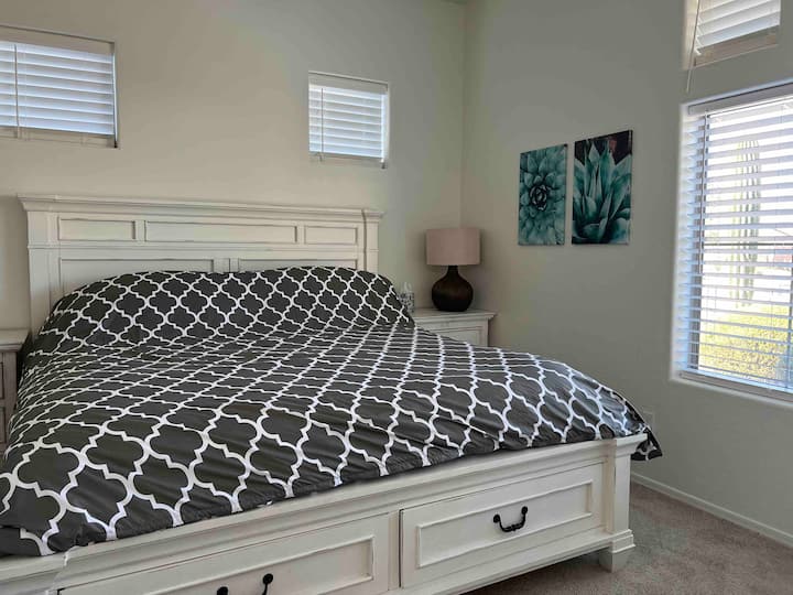 Dormitorio de invitados con vistas al jardín delantero del desierto con cama tamaño king.