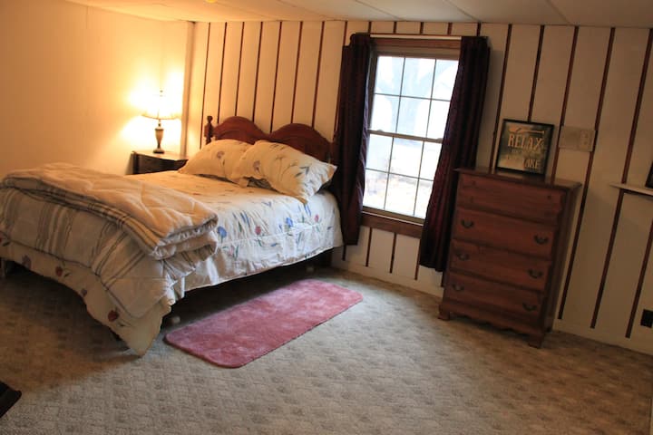 Საძინებელი დედოფლის ზომის საწოლით და ტბის ხედით.