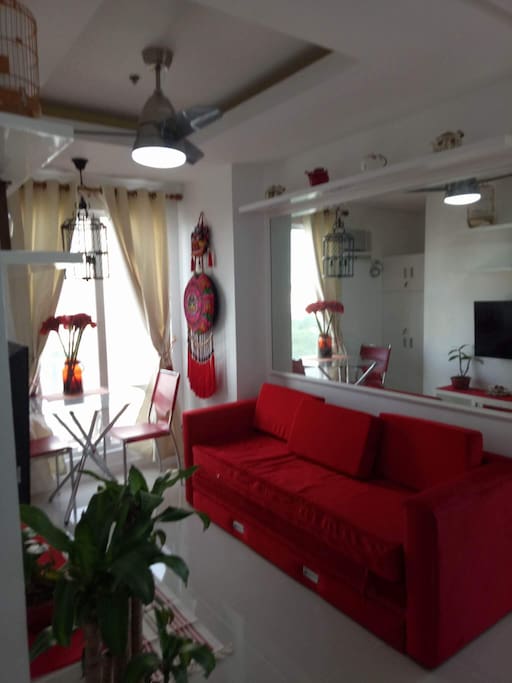 Bright and decorative living space, TV set , comfortable lounge chair and a dining set for two.