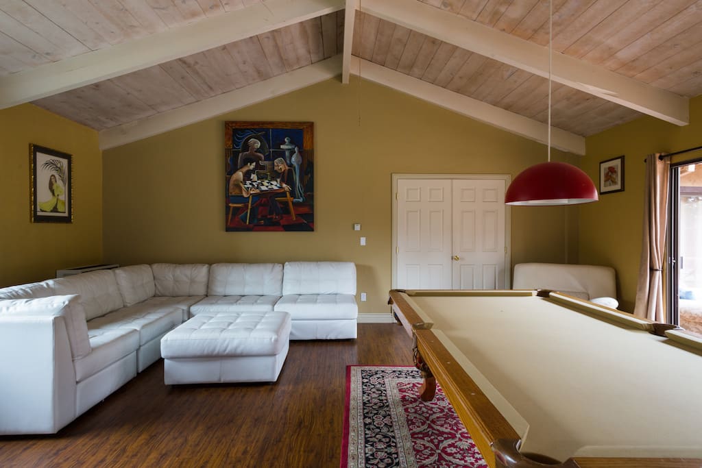 Game Room with pool table, modern leather sectional and ottoman