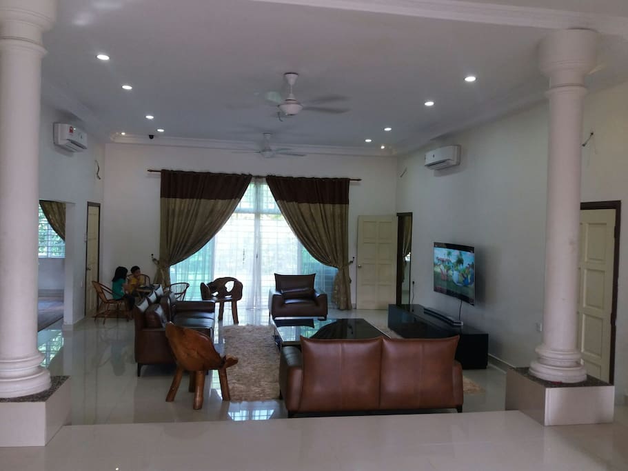 Comfortable living area with 6 seater leather sofa and WiFi 65 inches curved samsung TV.
