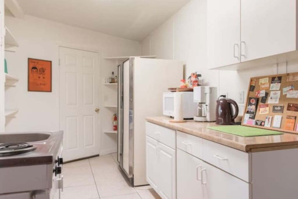 Kitchen with full size and mini fridge, stove, microwave, coffee maker and tea kettle
