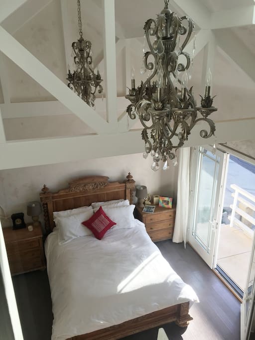 Bedroom with vaulted ceilings, artisan plaster and french doors to patio