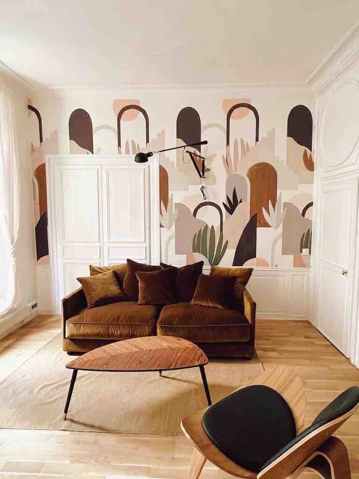 Prostor za sjedenje s baršunastim kaučem i udobnom dizajnerskom stolicom. Dođite i opustite se čitajući knjigu „Château de Versailles” koja vam je dostupna u stanu.