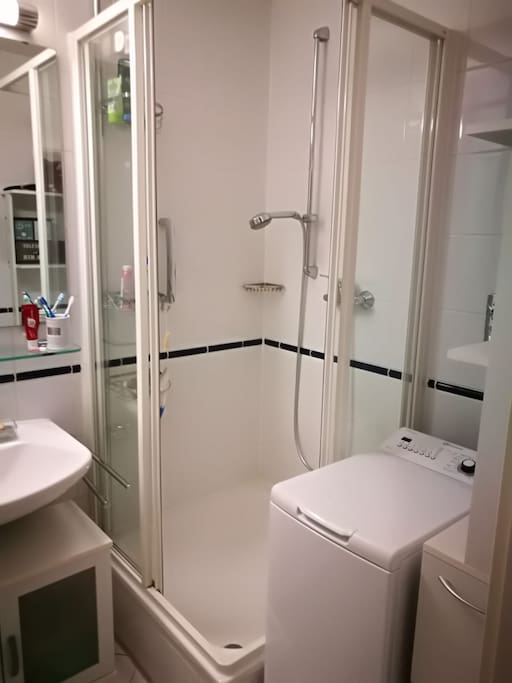 Badezimmer mit Dusche und Waschmaschine