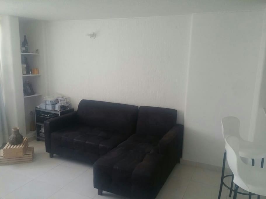 sala amplia con sofa que luede servir como cama para un tercer huesped
