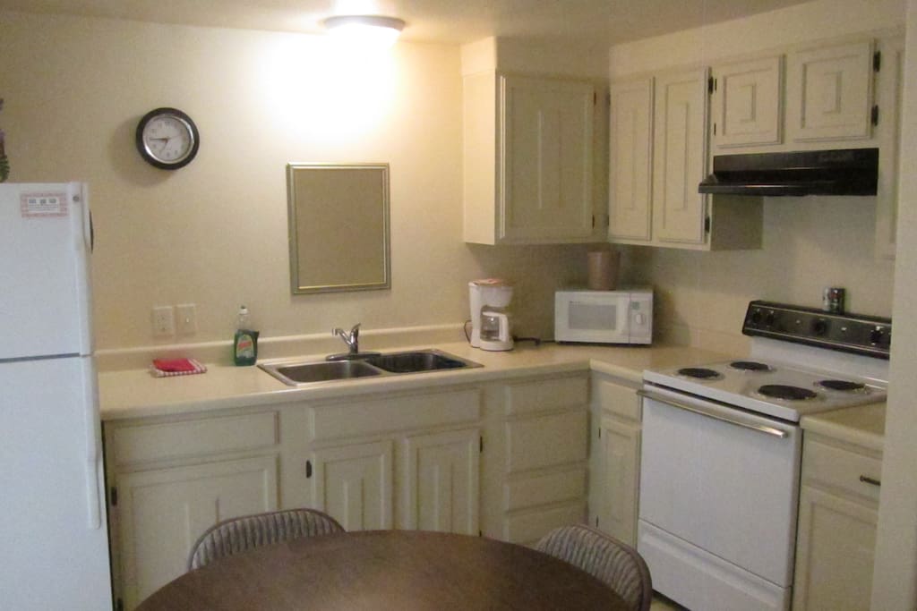 Spacious kitchen complete with dining and cooking sets.