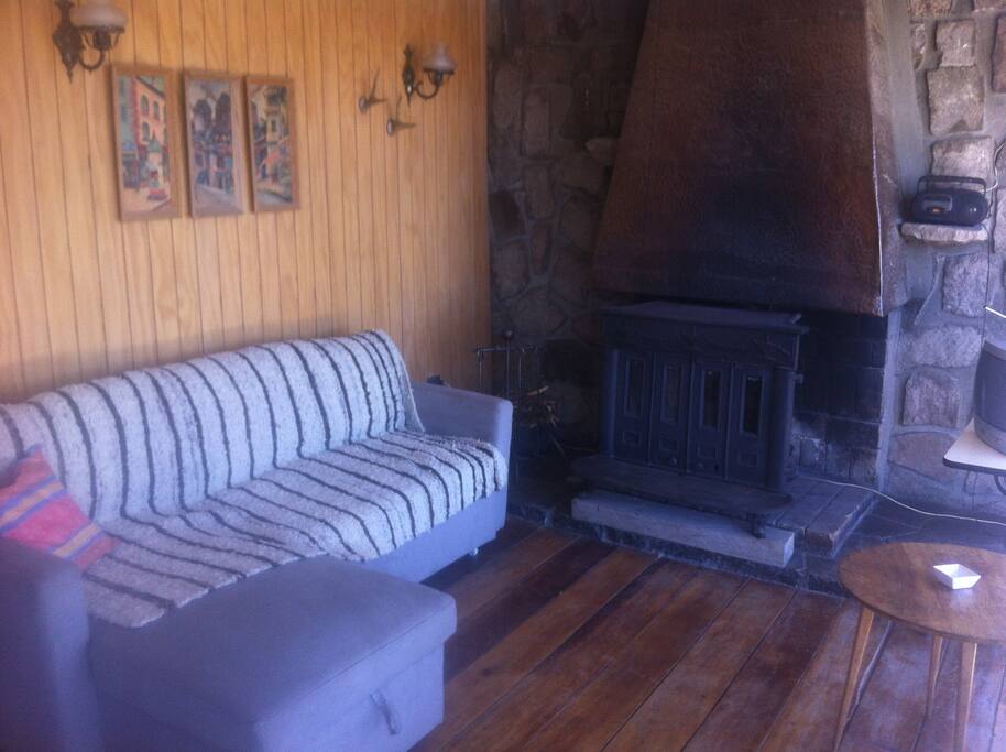 Estar con chimenea, cocina y comedor integrados