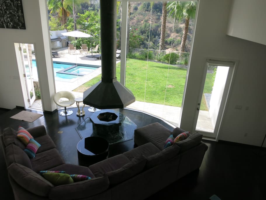 The living room with 25 ft ceilings looks out at the pool and the views beyond