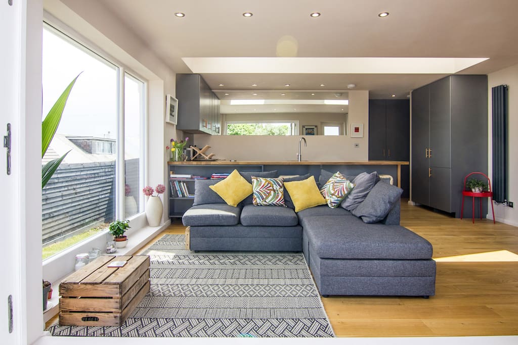 Open plan kitchen and seating area leading to outside patio/dining area with sea views