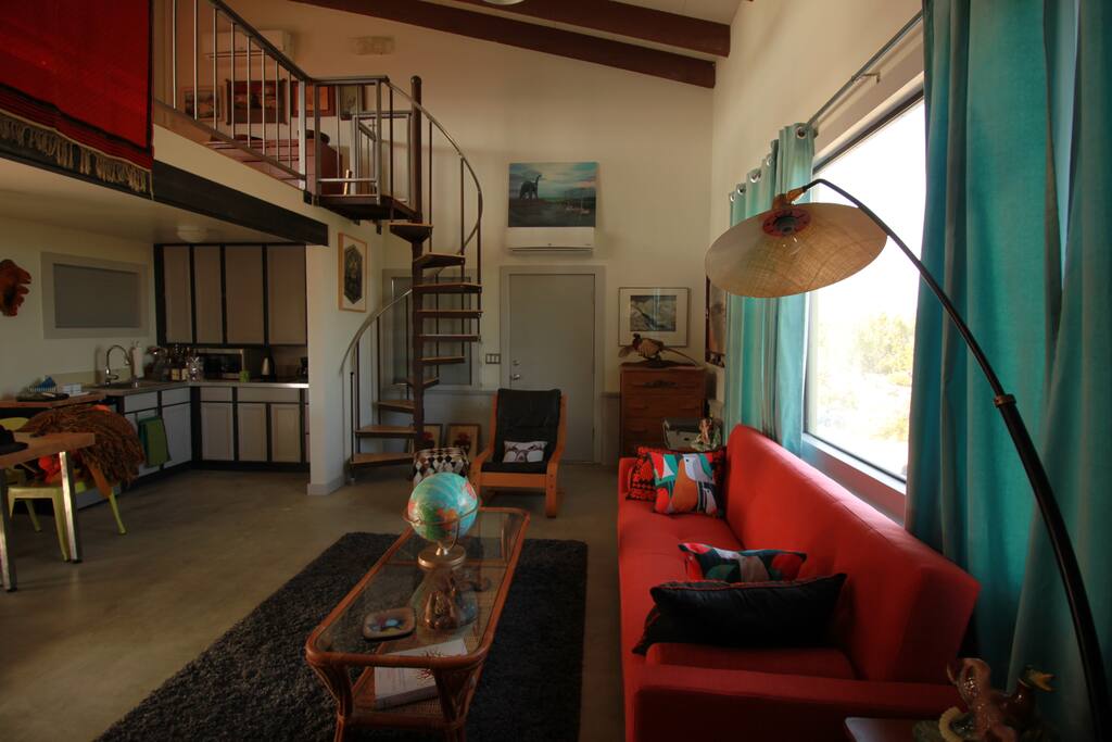 The cabin's main room. Has a fold out couch, a record player, and all you need to be comfortable and cozy. The circular stairs lead up to the loft style bedroom.