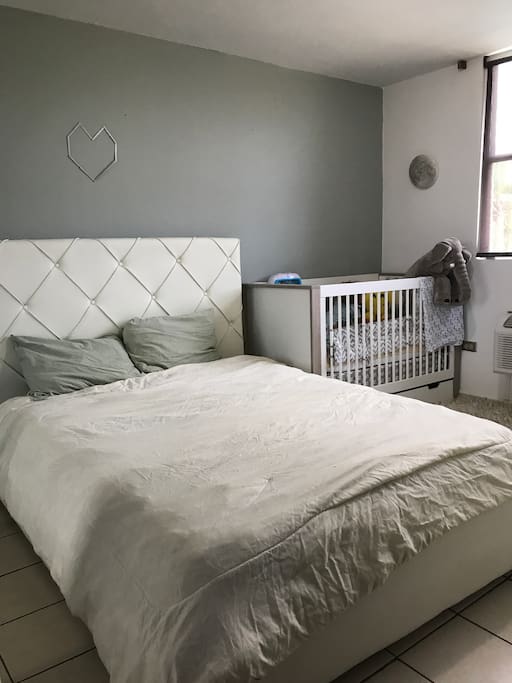Master bedroom with queen bed and crib.