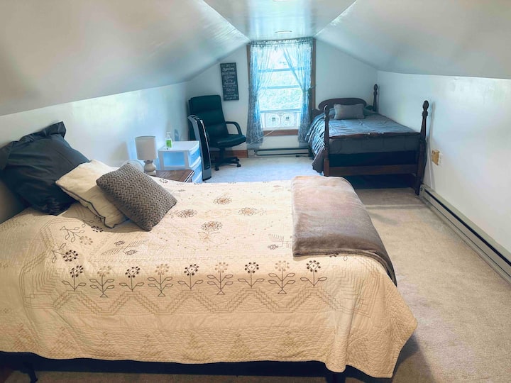 车库上方的楼上卧室配备一张全尺寸床和一张单人床