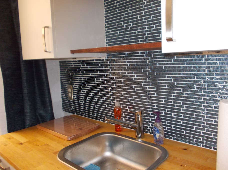 Close-up Kitchenette glass backsplash and butcher block countertop