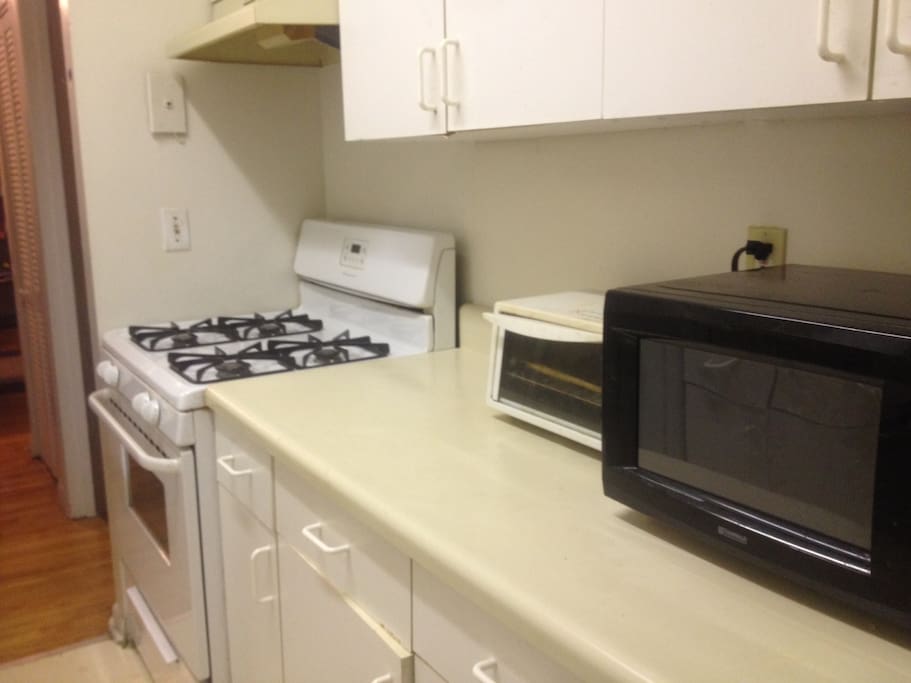 Kitchen with microwave, toaster oven, and gas stove.